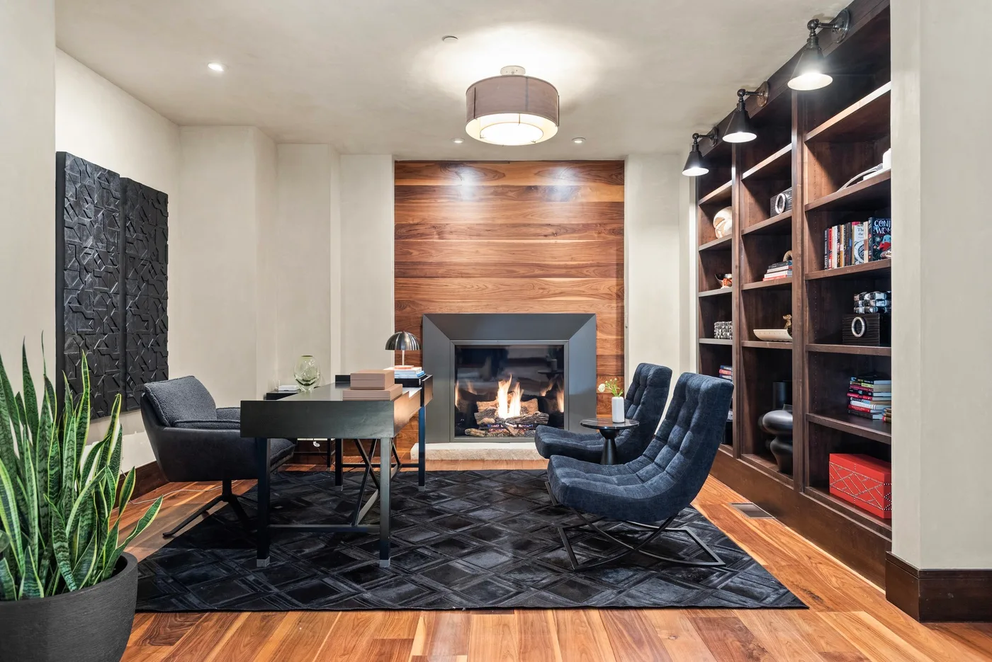 Una sala de estar con chimenea, asientos y estanterías empotradas.