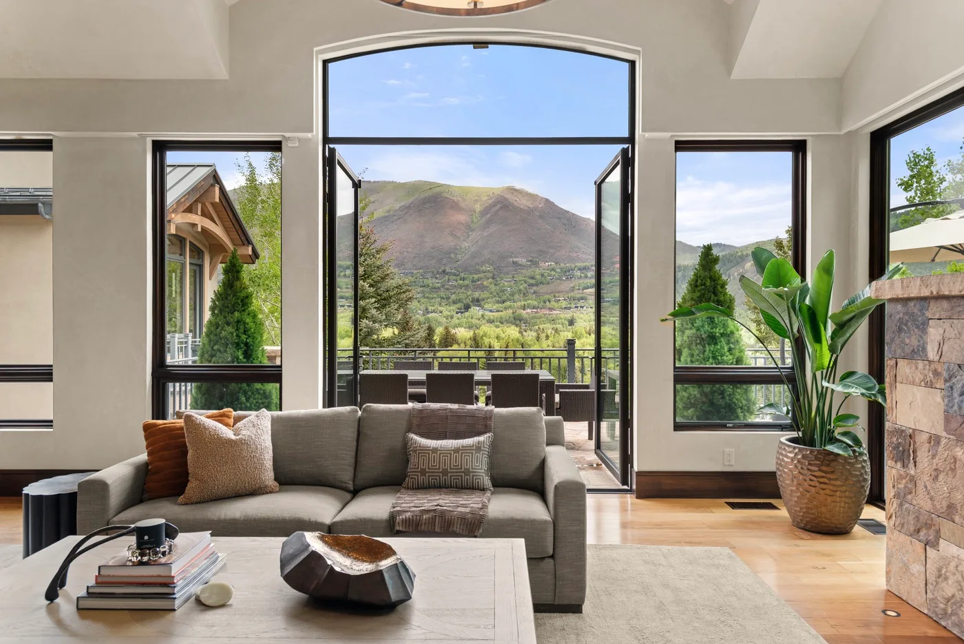 Una sala de estar con asientos junto a ventanales que dan a un paisaje montañoso.