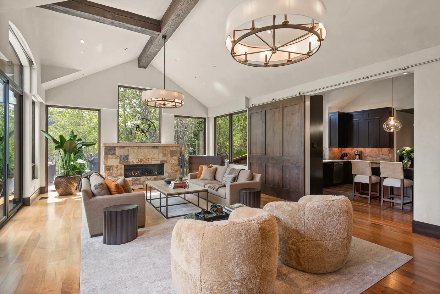 Una sala luminosa con chimenea, asientos y grandes ventanas.