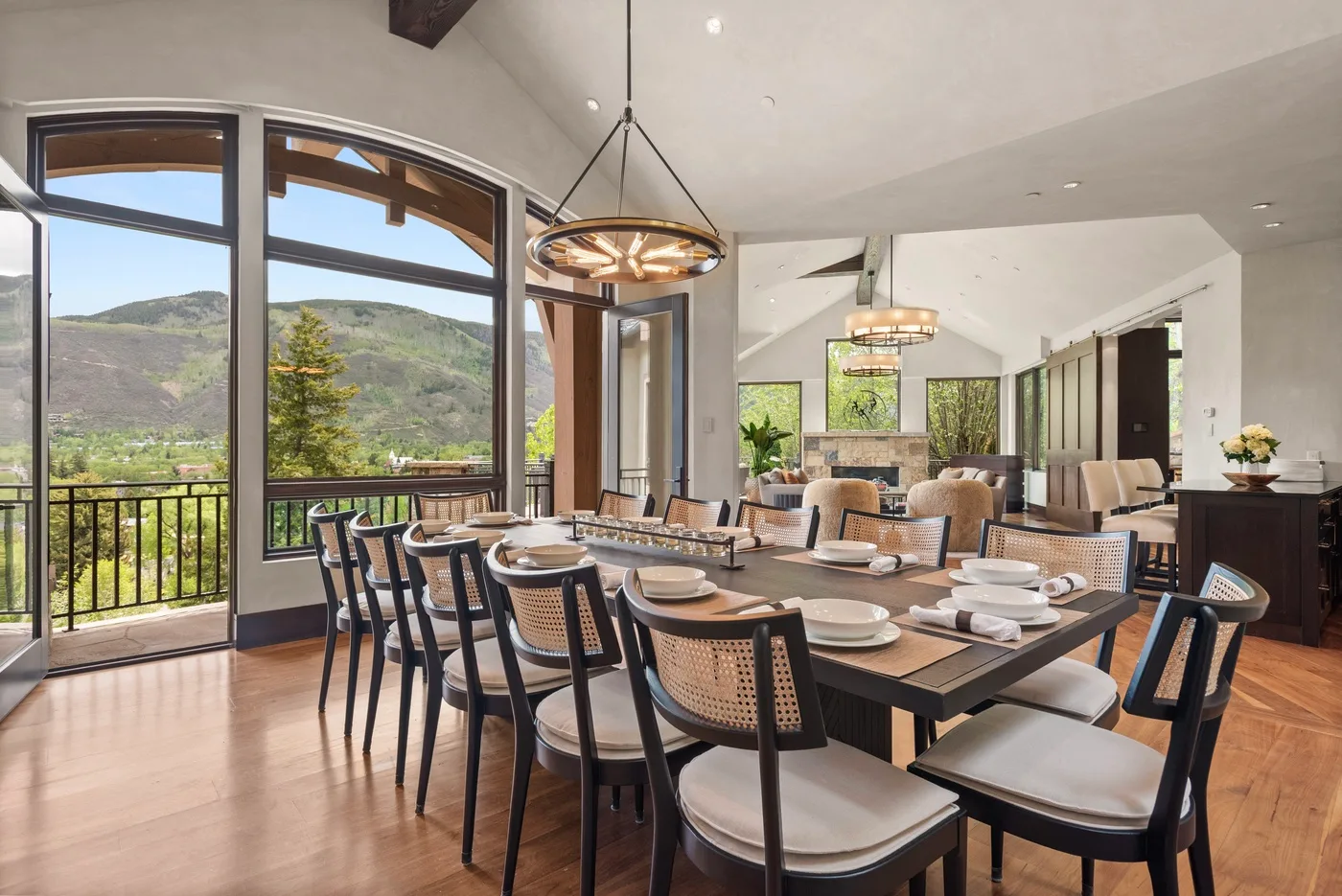 Comedor con una mesa larga y grandes ventanales con vistas a las colinas.
