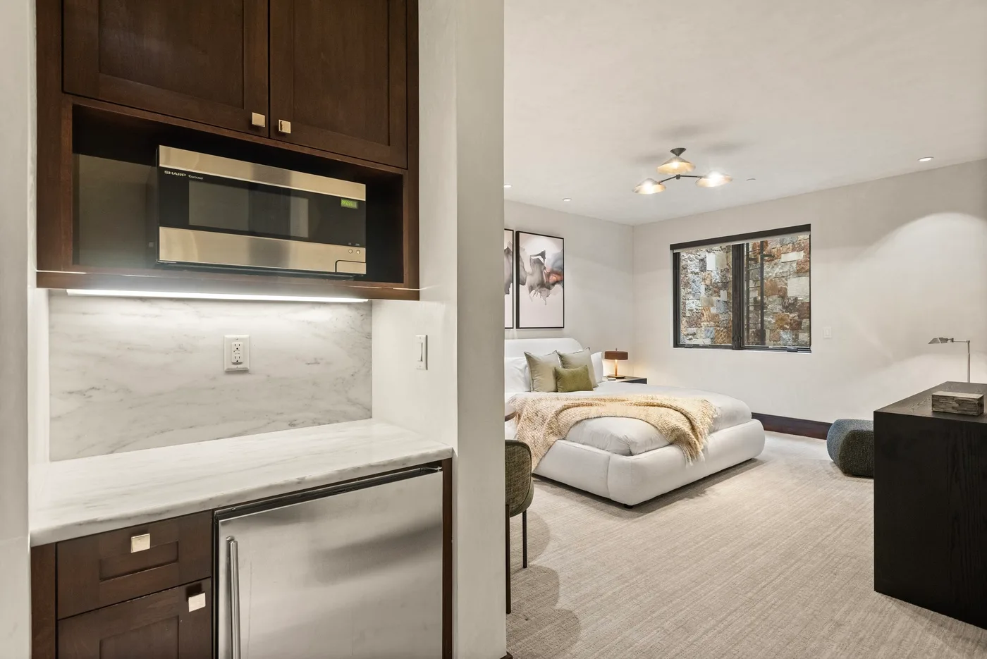 Dormitorio con una cama, arte en la pared y armarios empotrados.