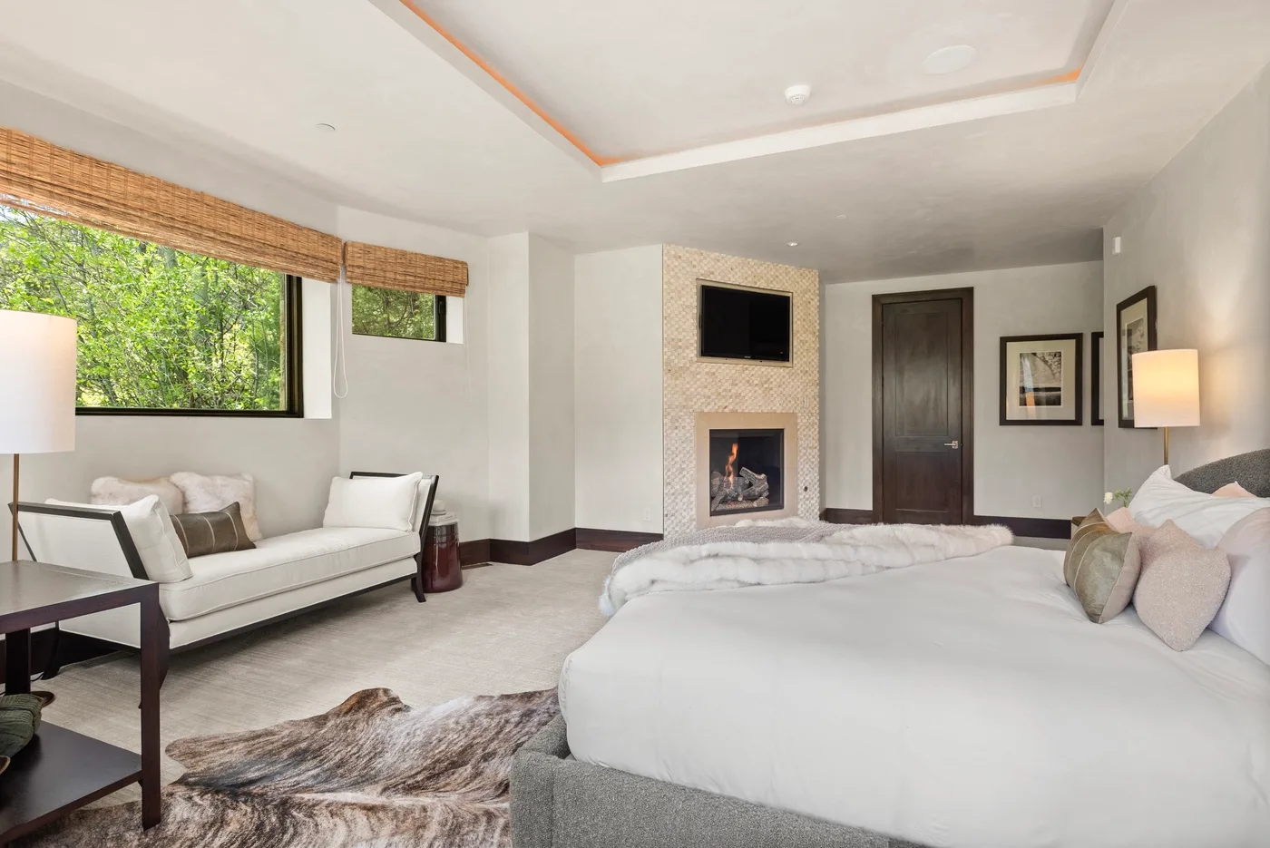 Un dormitorio con una cama grande, una zona de estar y una chimenea.