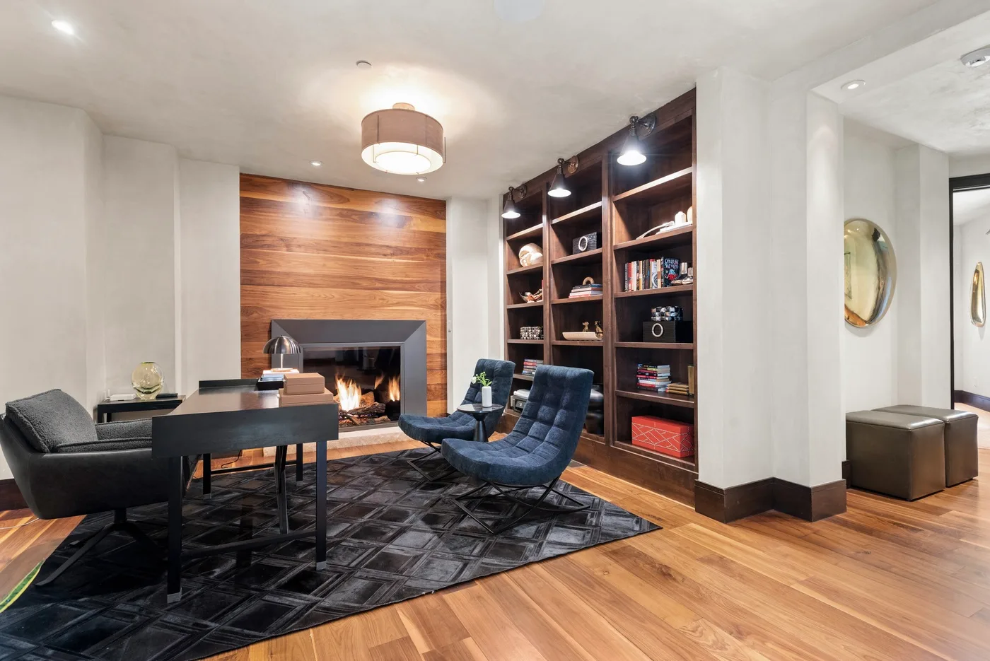 Una sala de estar con chimenea, asientos y estanterías empotradas.
