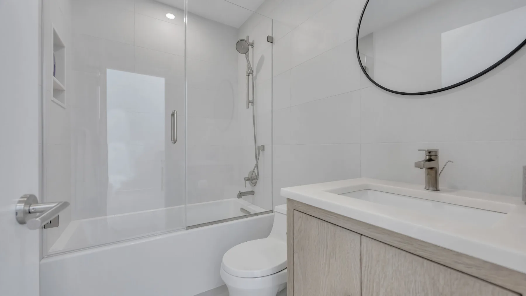 A bright bathroom with a bathtub, shower, toilet, and vanity.