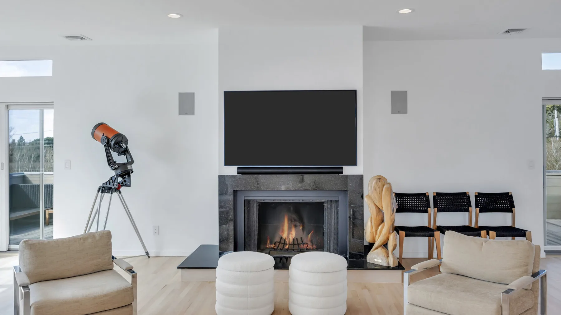A bright living room with a fireplace, television, and seating.