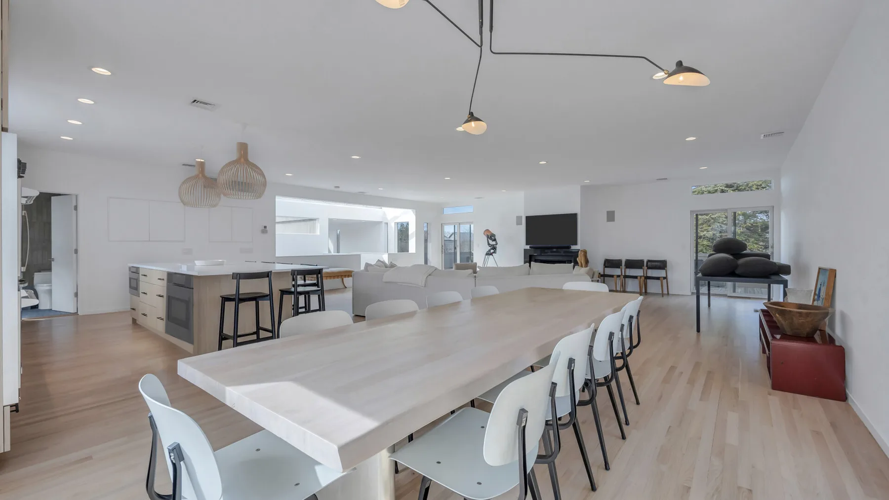 A bright open dining area with a long table and rows of chairs.