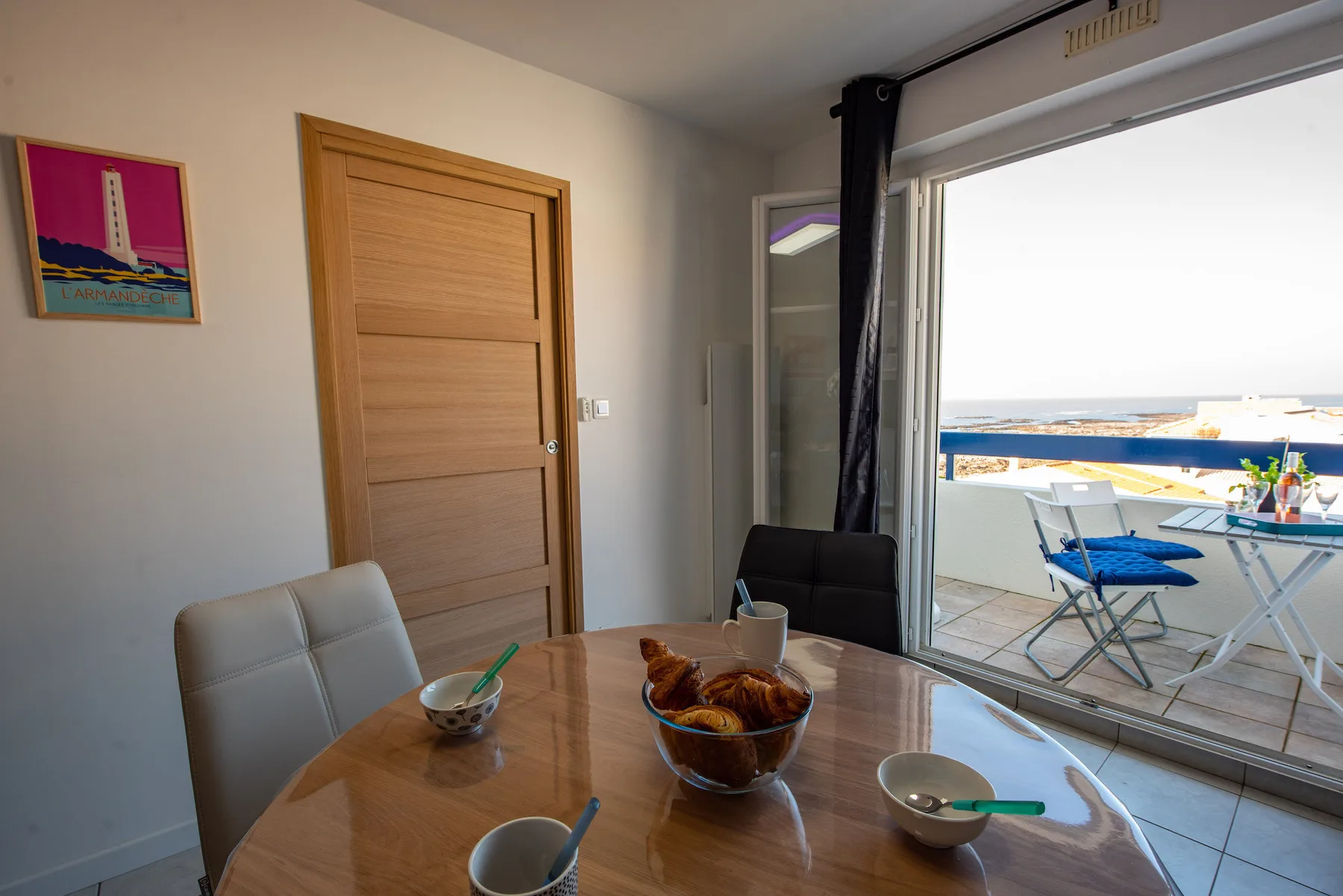 A dining area with a round table beside sliding glass doors opening onto a balcony.