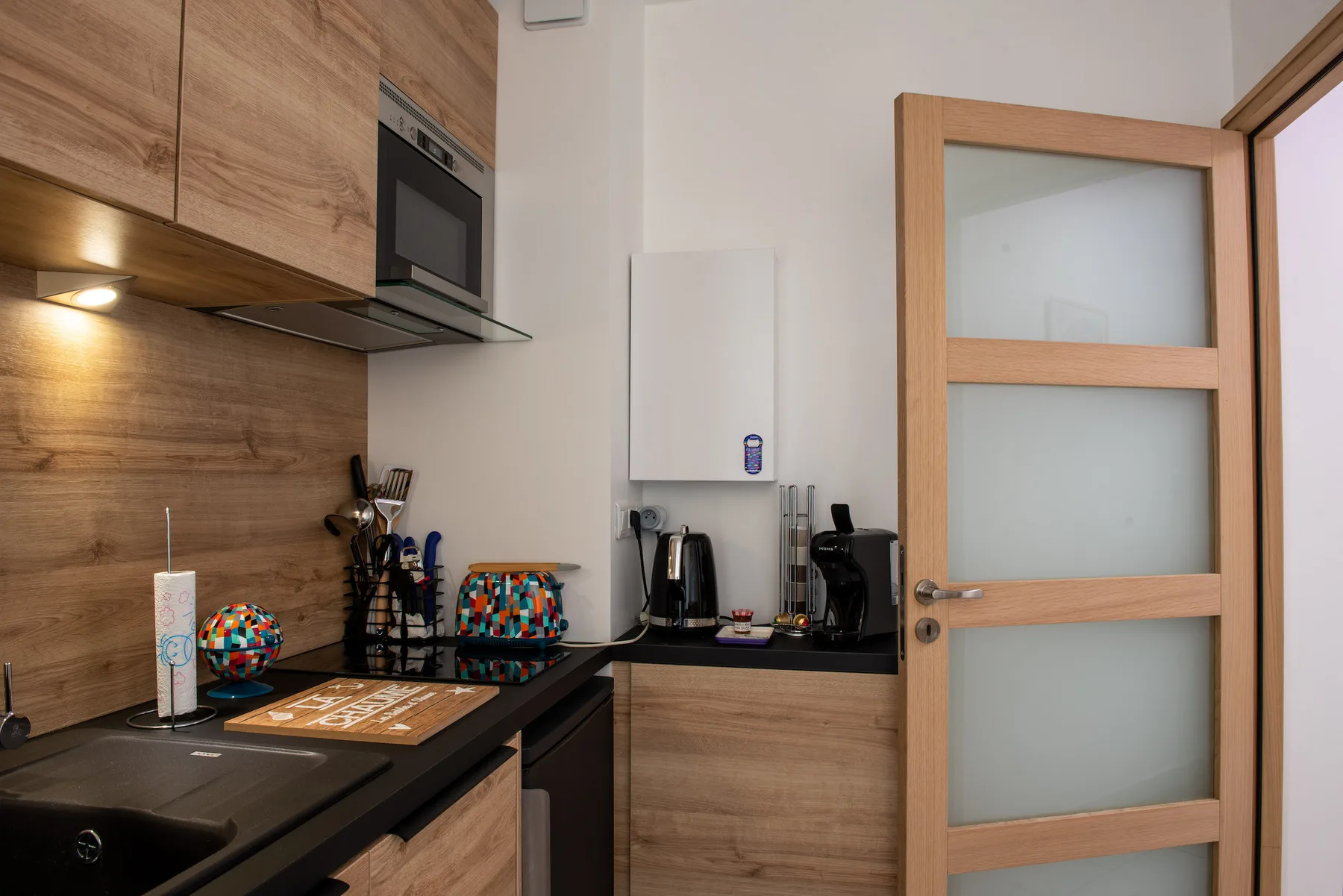 Kitchen with wood cabinetry, a cooktop, and countertop appliances.
