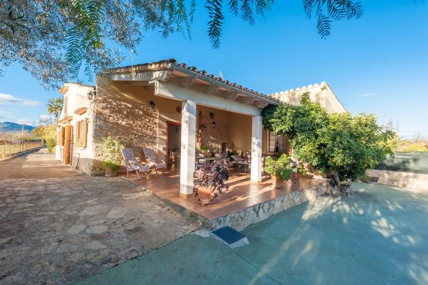 Un patio de piedra junto a una zona de estar cubierta y una piscina.
