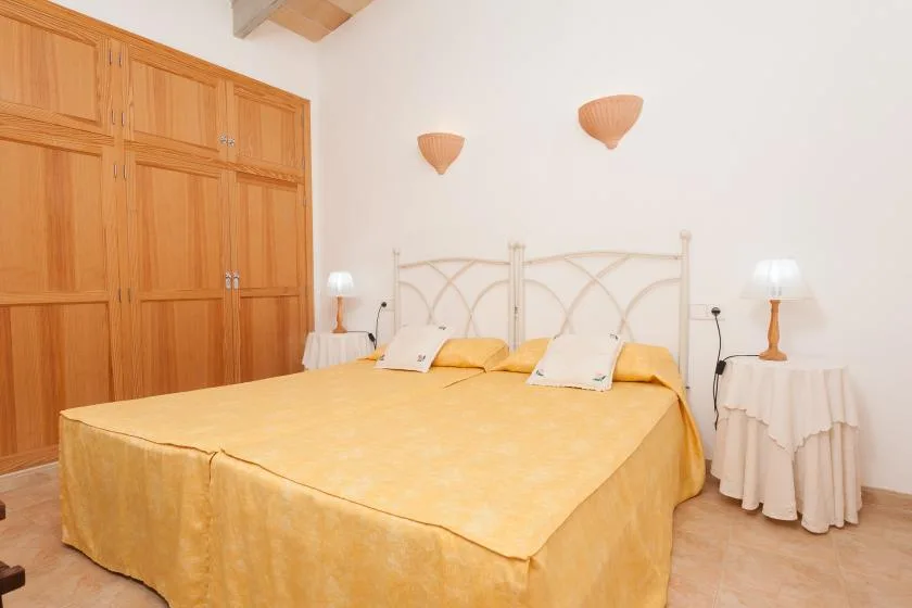 Un dormitorio con una cama grande, armarios de madera y apliques de pared.