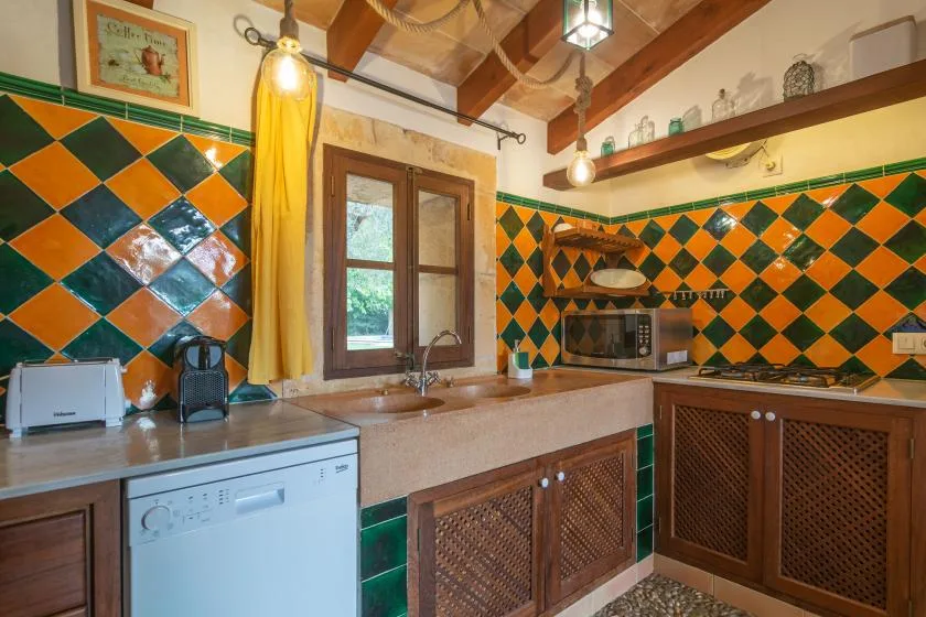 Una cocina alicatada con encimera, fregadero y armarios de madera.