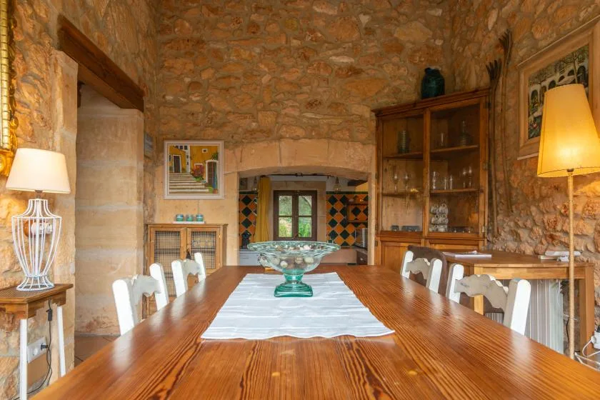 Un comedor rústico con una mesa larga de madera y paredes de piedra.