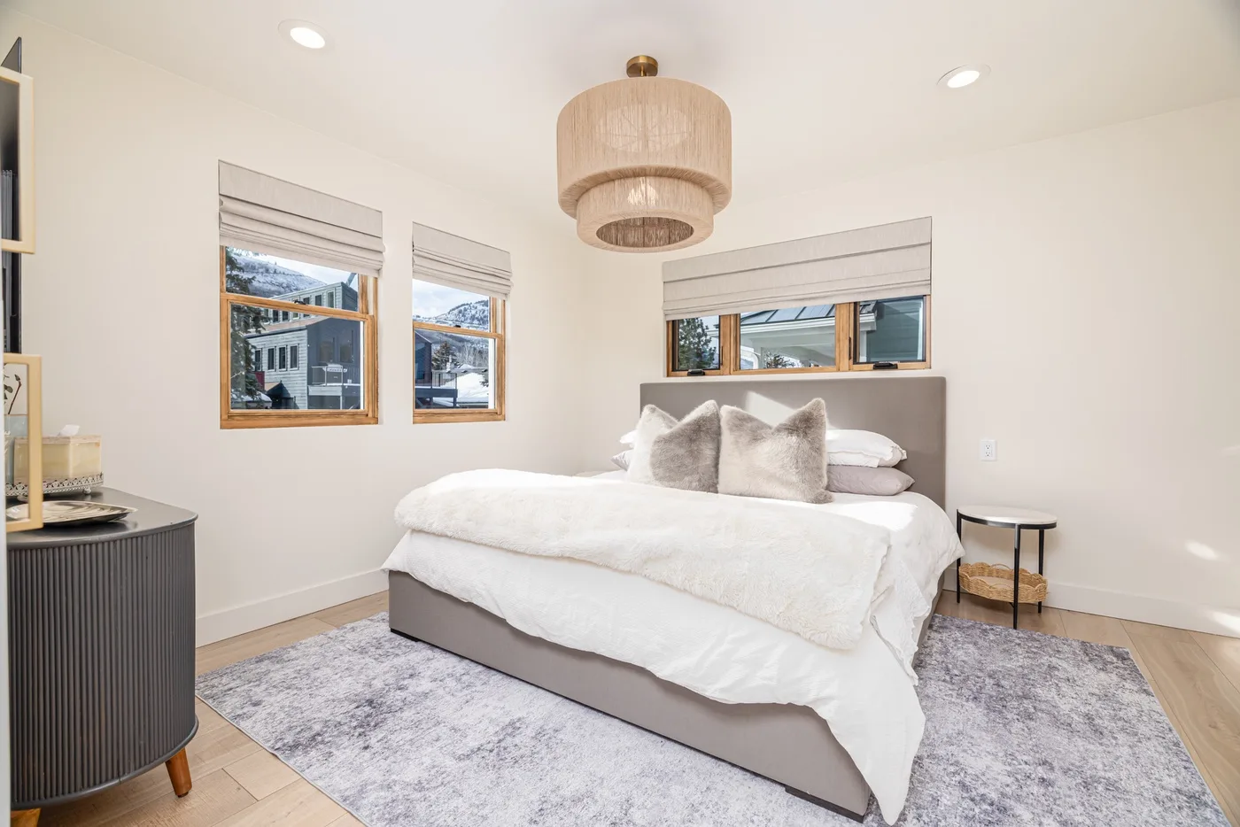 Un dormitorio luminoso con una cama, ropa de cama suave y ventanas.
