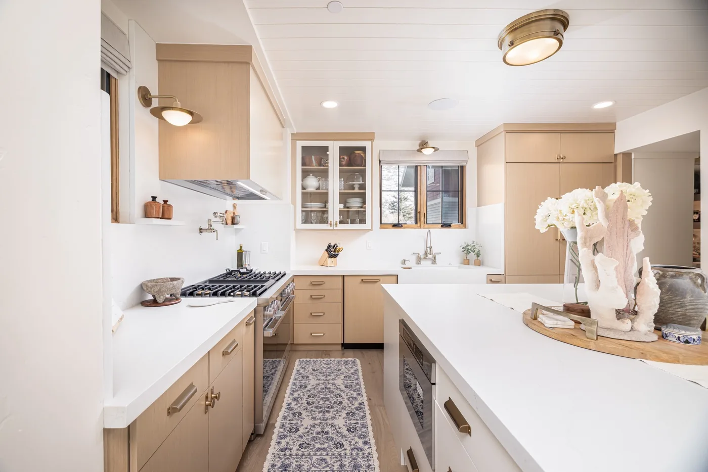 Una cocina luminosa con gabinetes claros, una isla central y una ventana.