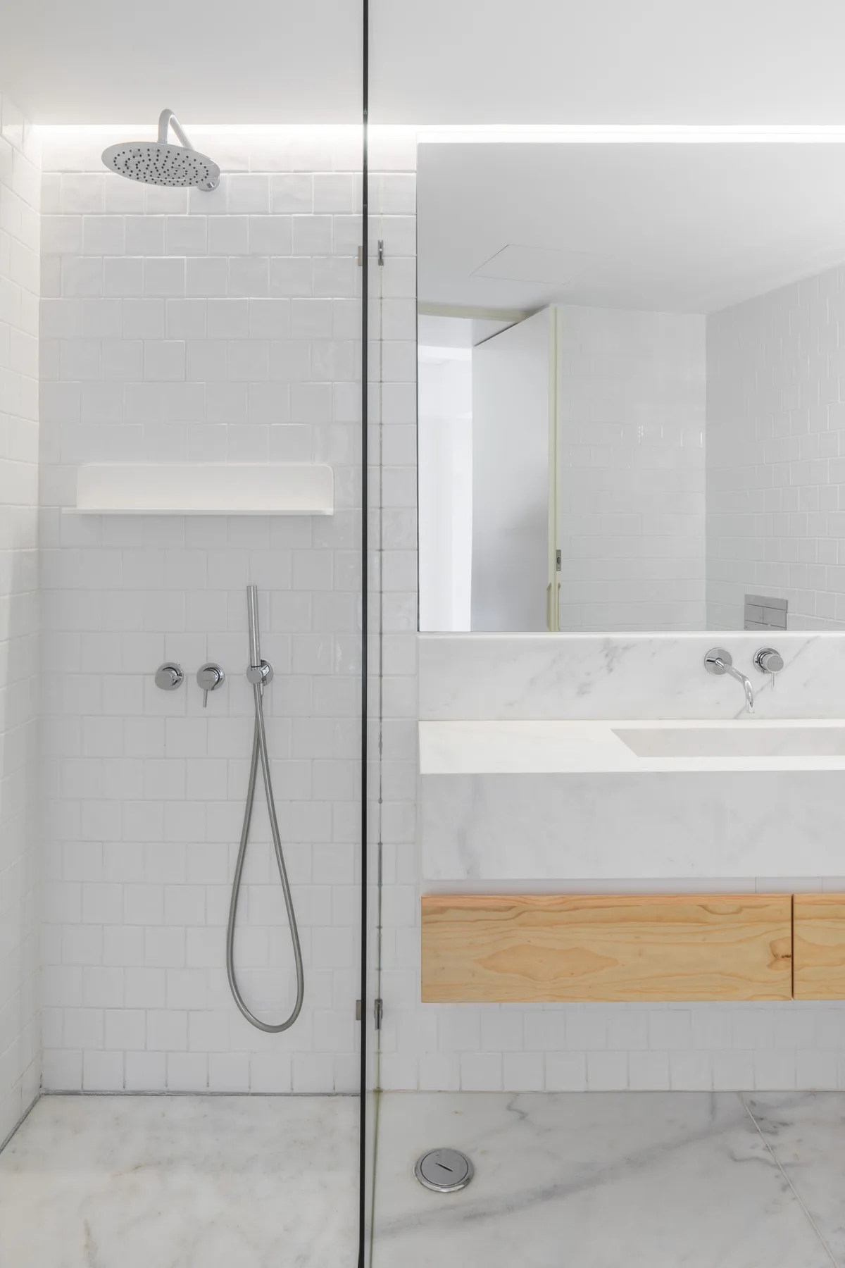 A bright bathroom with a glass-enclosed shower and a sink vanity.