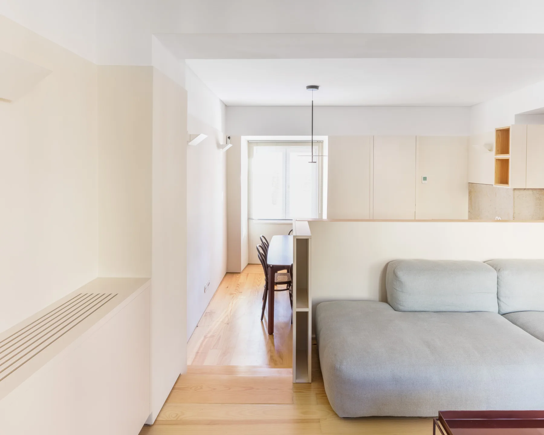 Una luminosa sala de estar con asientos y una mesa de comedor junto a la ventana.