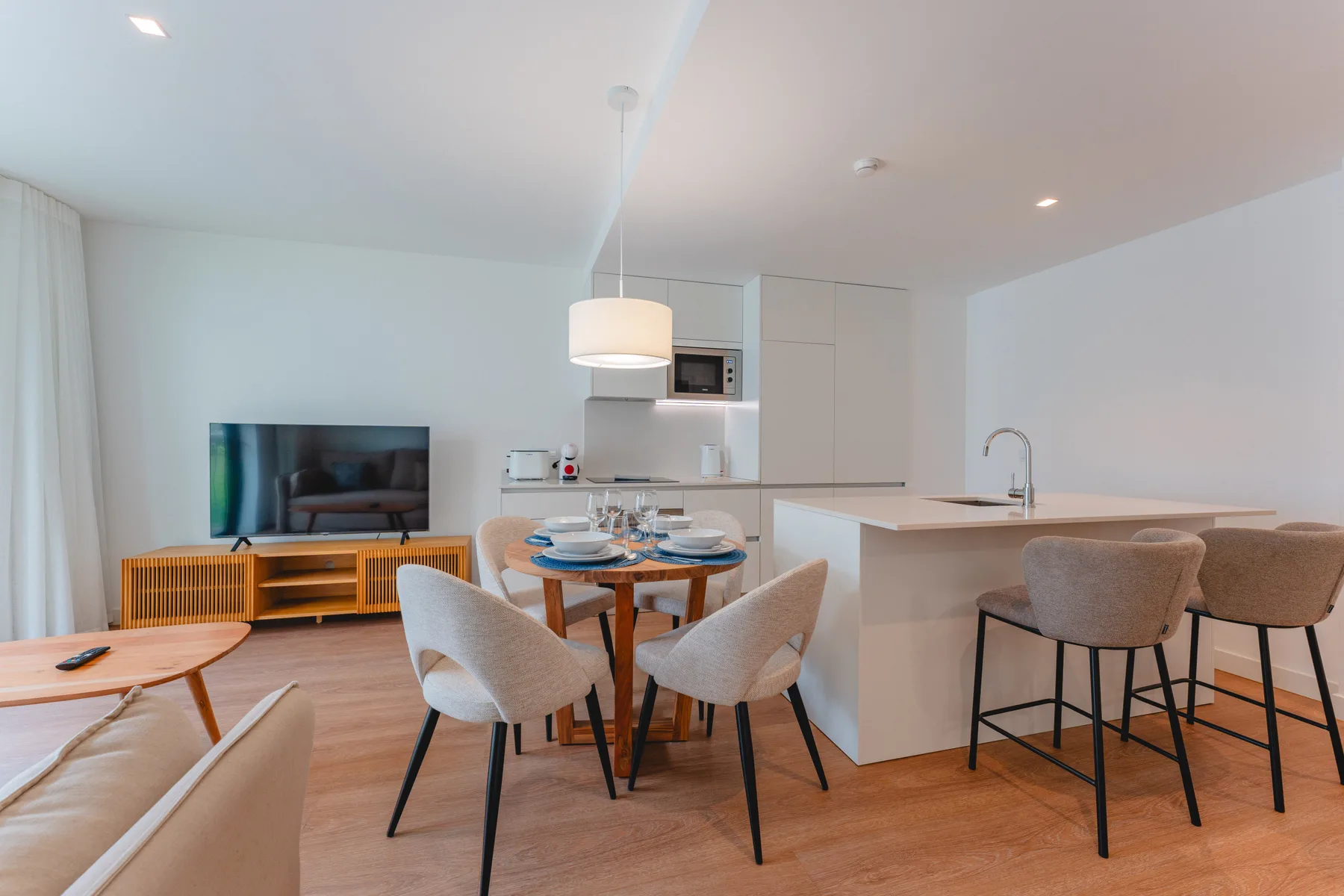 An open-plan living and dining area with a television and kitchen island.