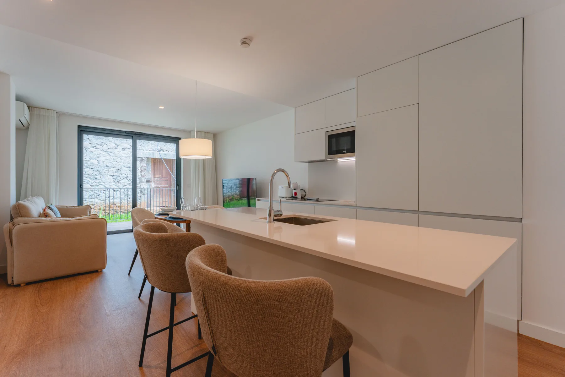 An open-plan kitchen and dining area has a long counter with bar seating.