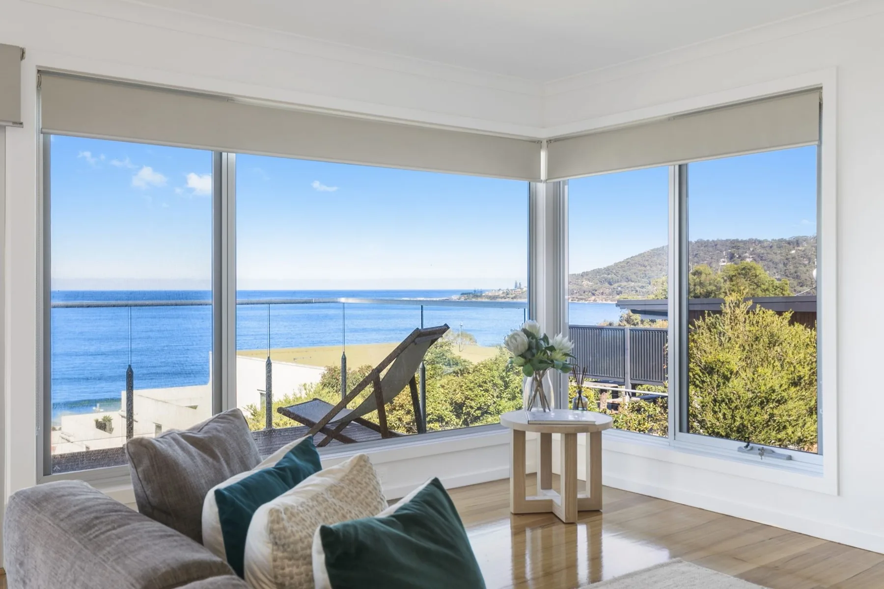 A bright living room with corner windows overlooking the ocean.