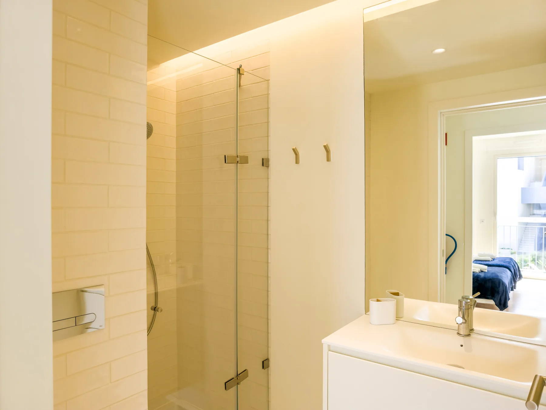 A bright bathroom has a glass shower and a white sink vanity.