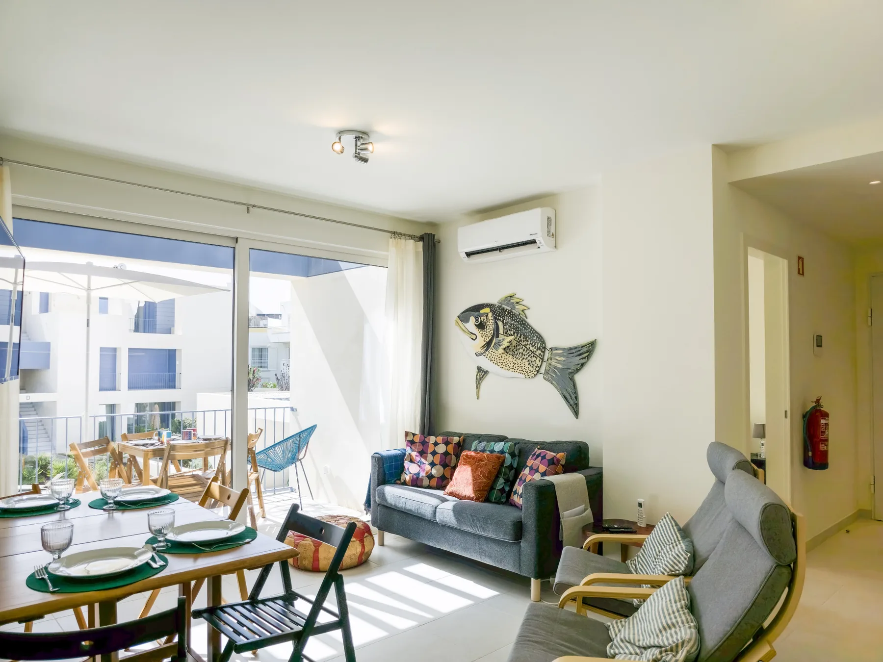 A bright living and dining area with seating beside large windows.