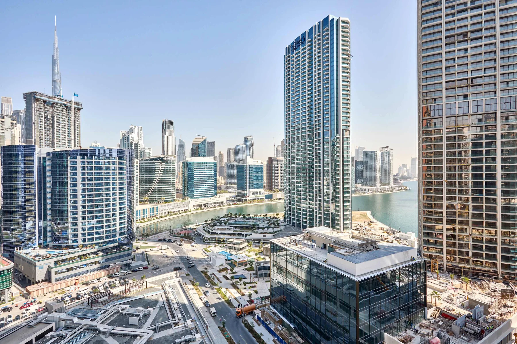 Un horizonte urbano de edificios modernos junto a un paseo marítimo curvo.