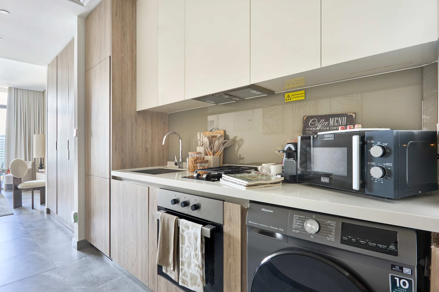 Una cocina moderna con encimera, placa de cocina, microondas y electrodomésticos de lavandería.