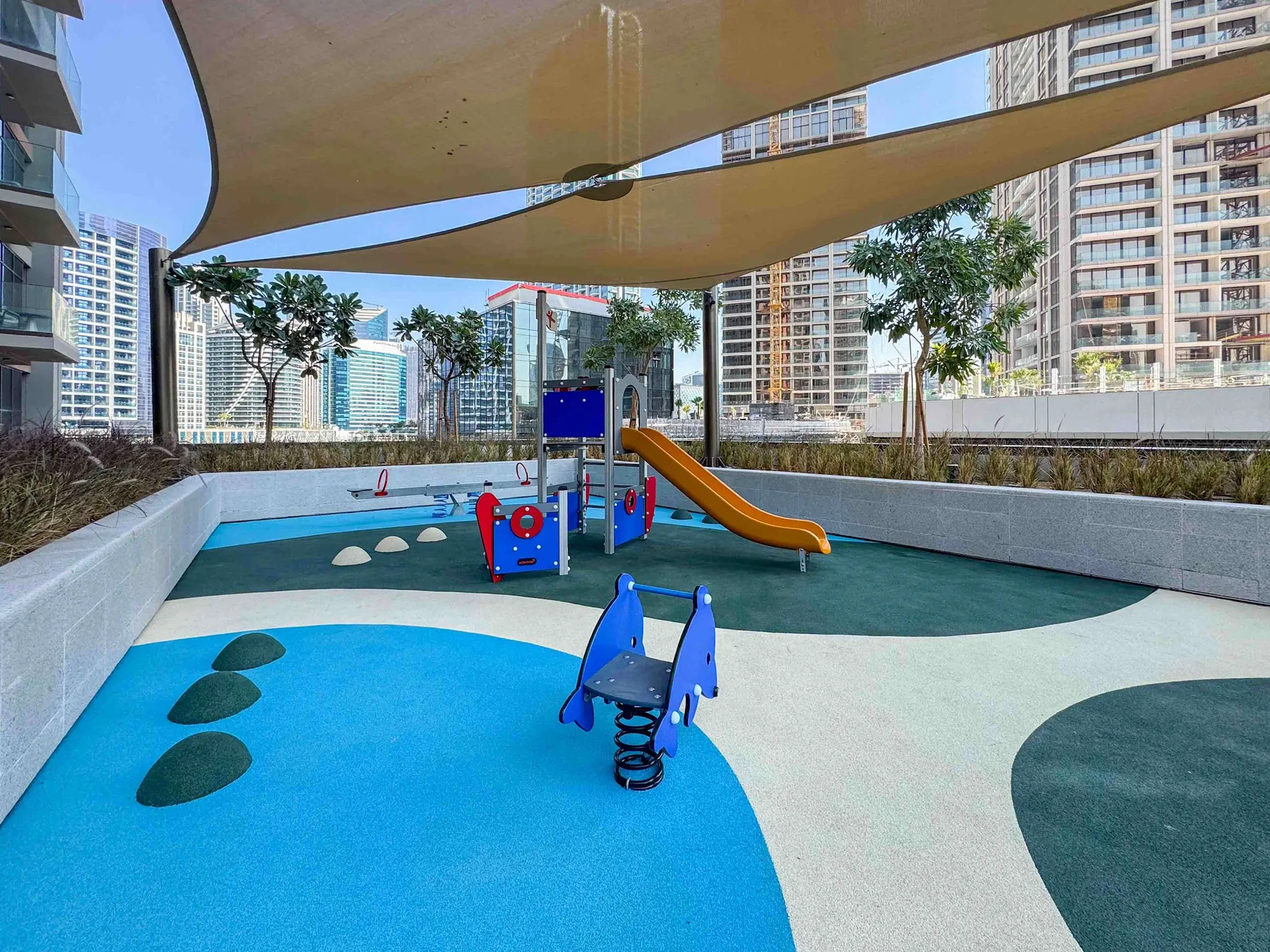 Un parque infantil al aire libre con equipos coloridos para trepar y un tobogán.
