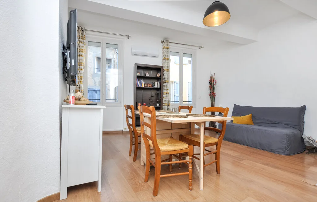 Comedor con una mesa de madera y asientos junto a un sofá gris.