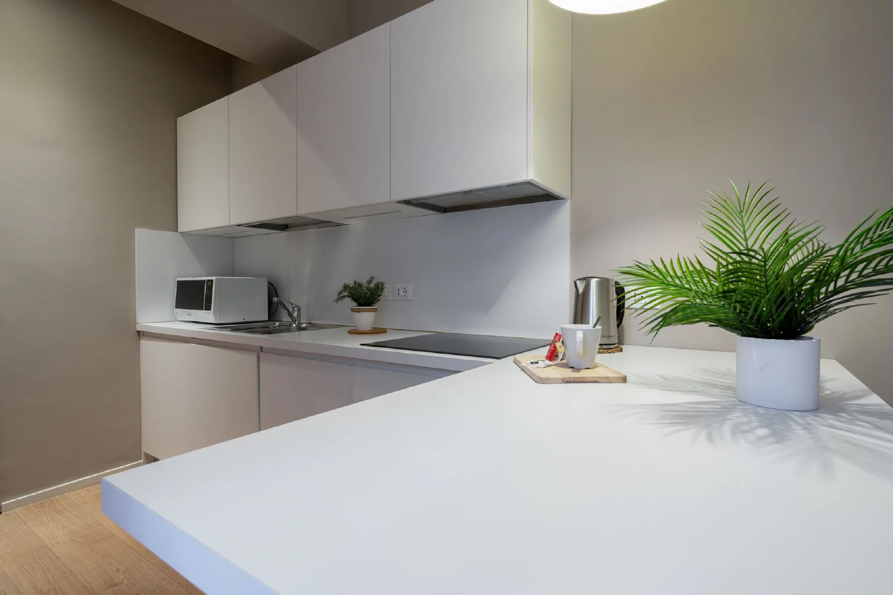 Una cocina moderna con gabinetes blancos y una isla grande.