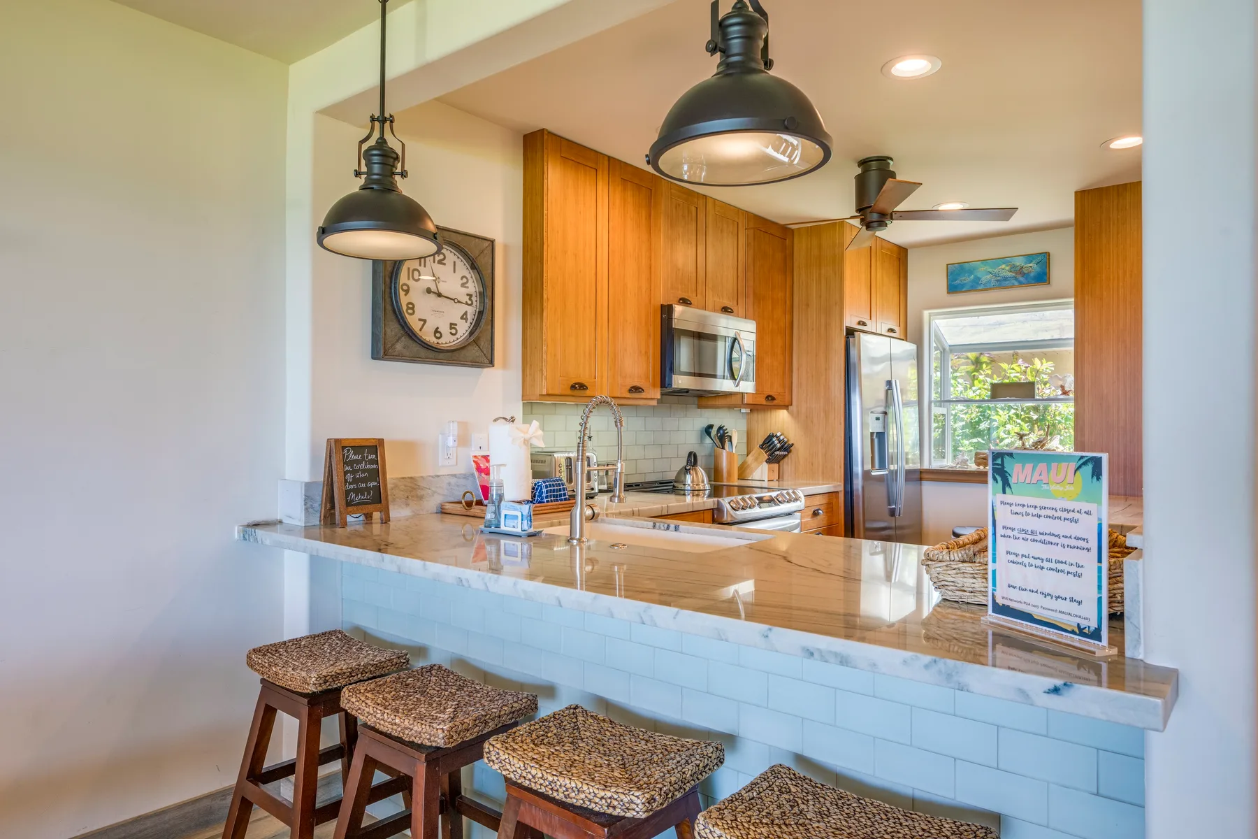 Una cocina luminosa con una barra larga, gabinetes de madera y taburetes.
