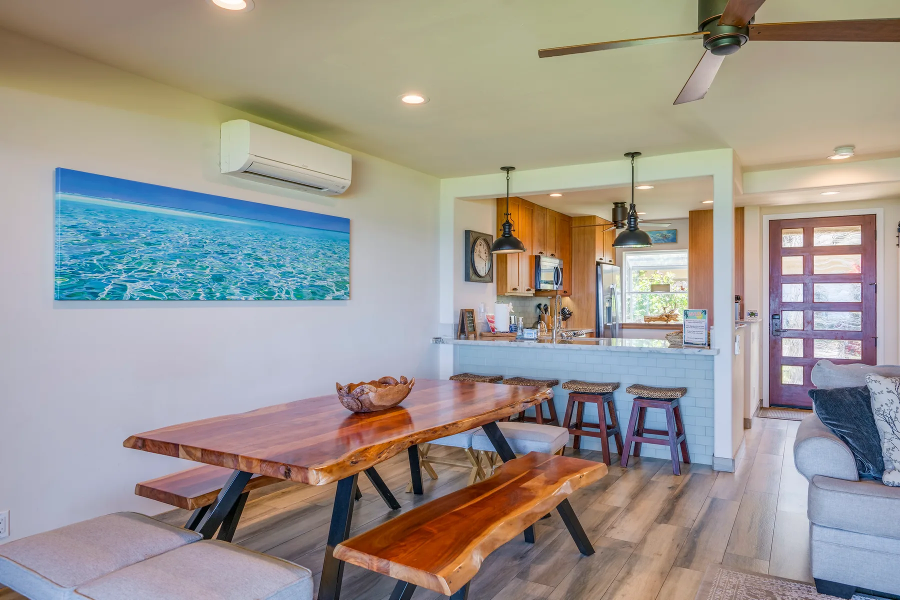 Una sala-comedor de espacio abierto con una mesa de madera y la cocina al fondo.