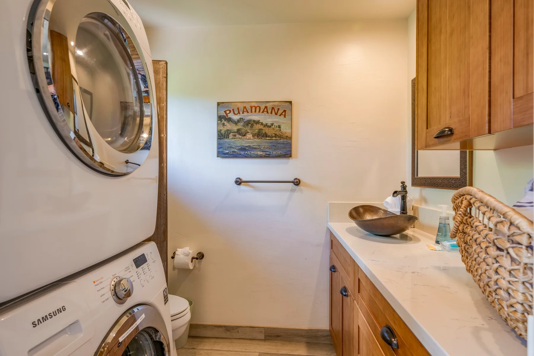 Zona de lavandería y baño con una lavadora y una encimera larga.