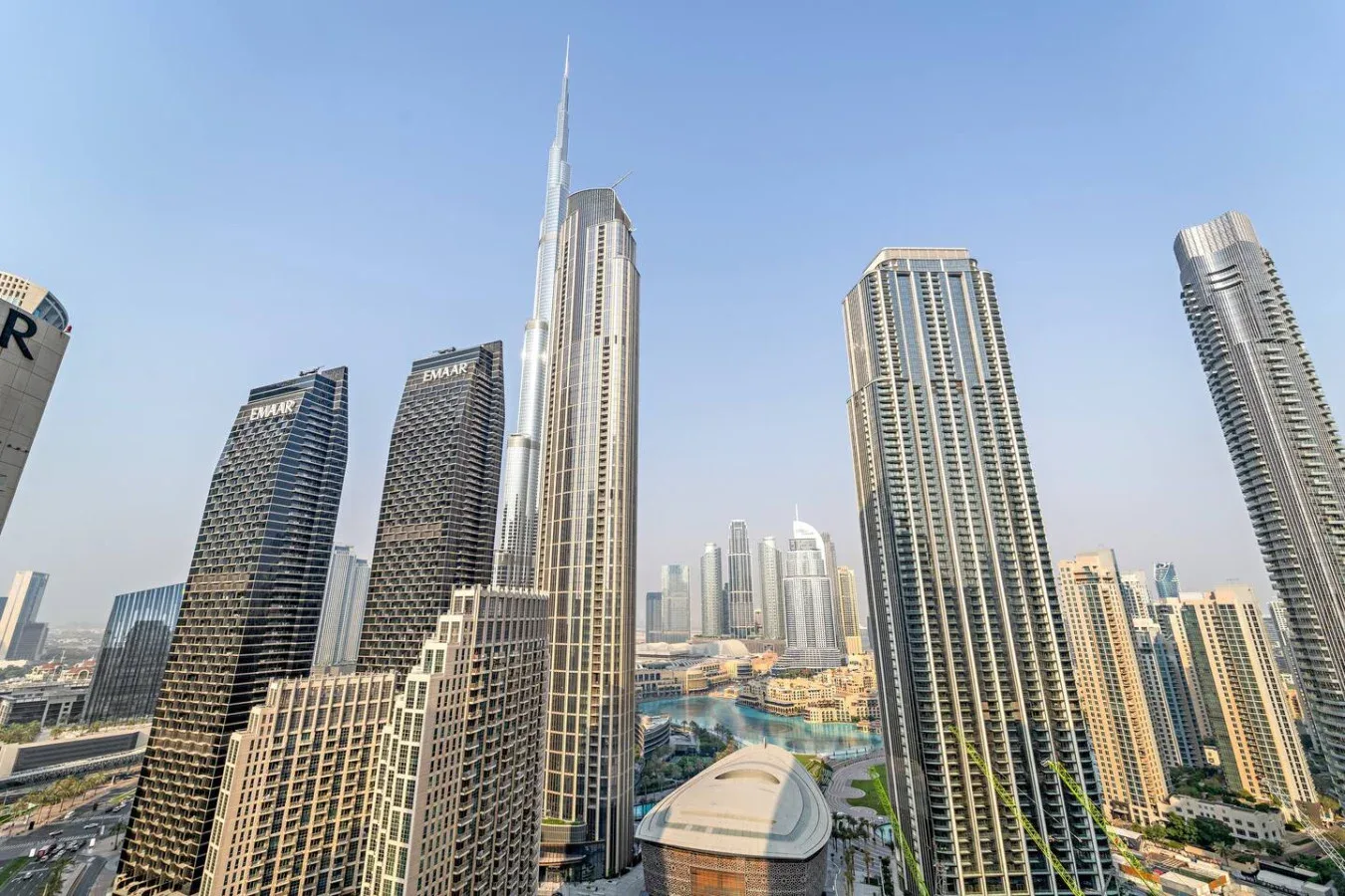 City skyline with tall modern buildings beneath a clear blue sky.