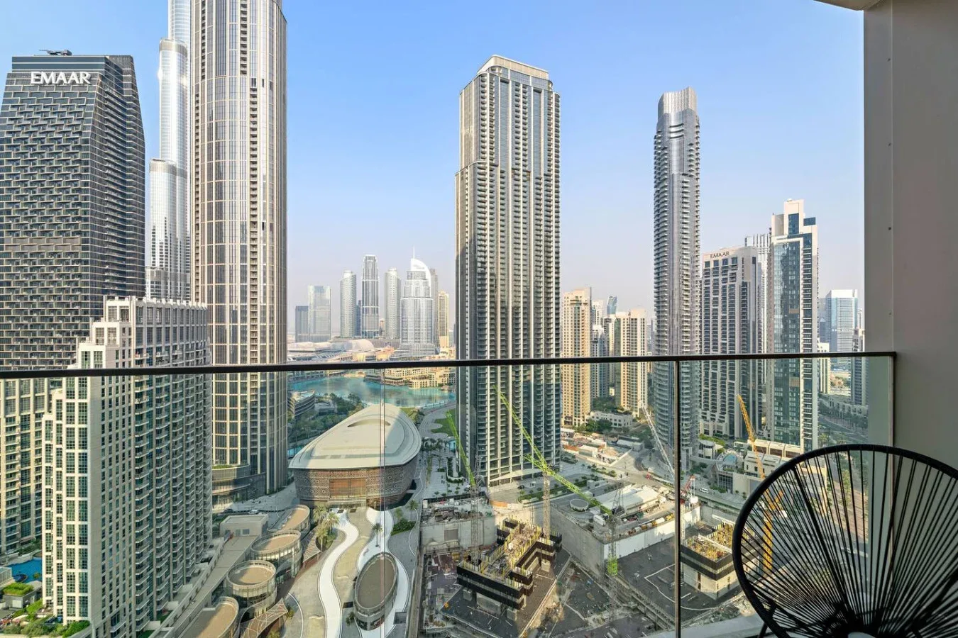 A balcony overlooks a dense skyline of modern high-rise buildings.