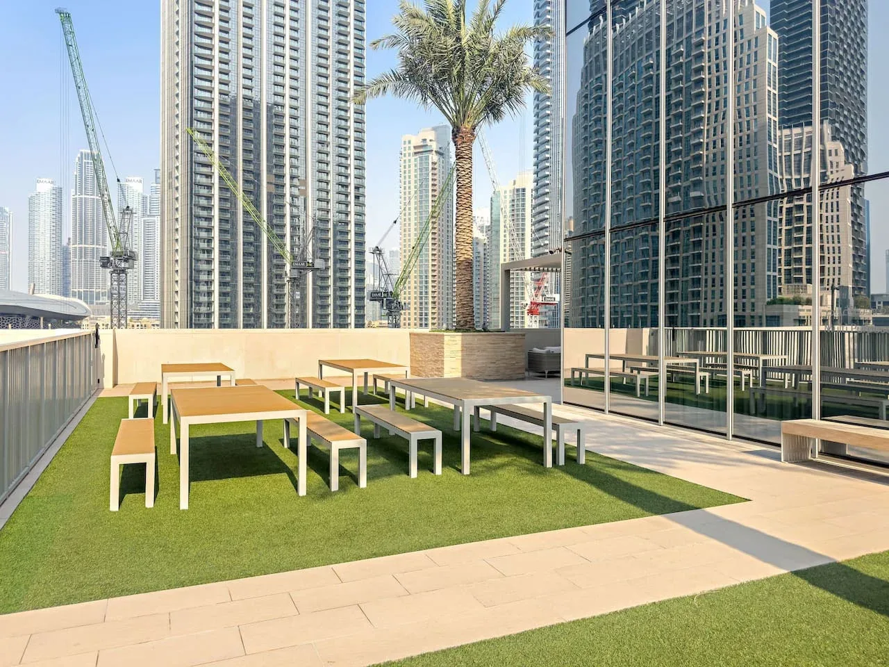 A rooftop terrace with outdoor seating and tall city buildings in the background.