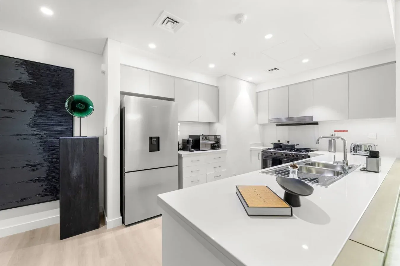 A bright modern kitchen with white cabinetry and a large island.