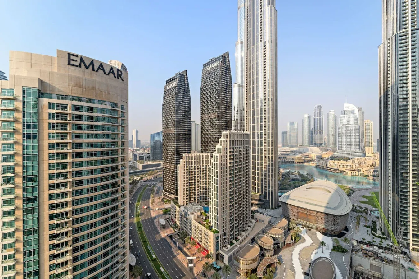 A city skyline with tall modern buildings and a winding road below.
