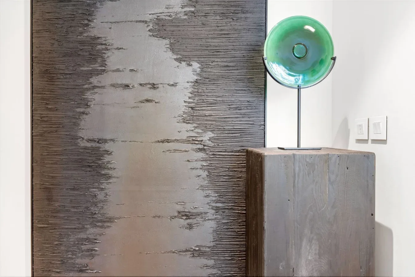 A modern interior features abstract wall art above a wooden console.