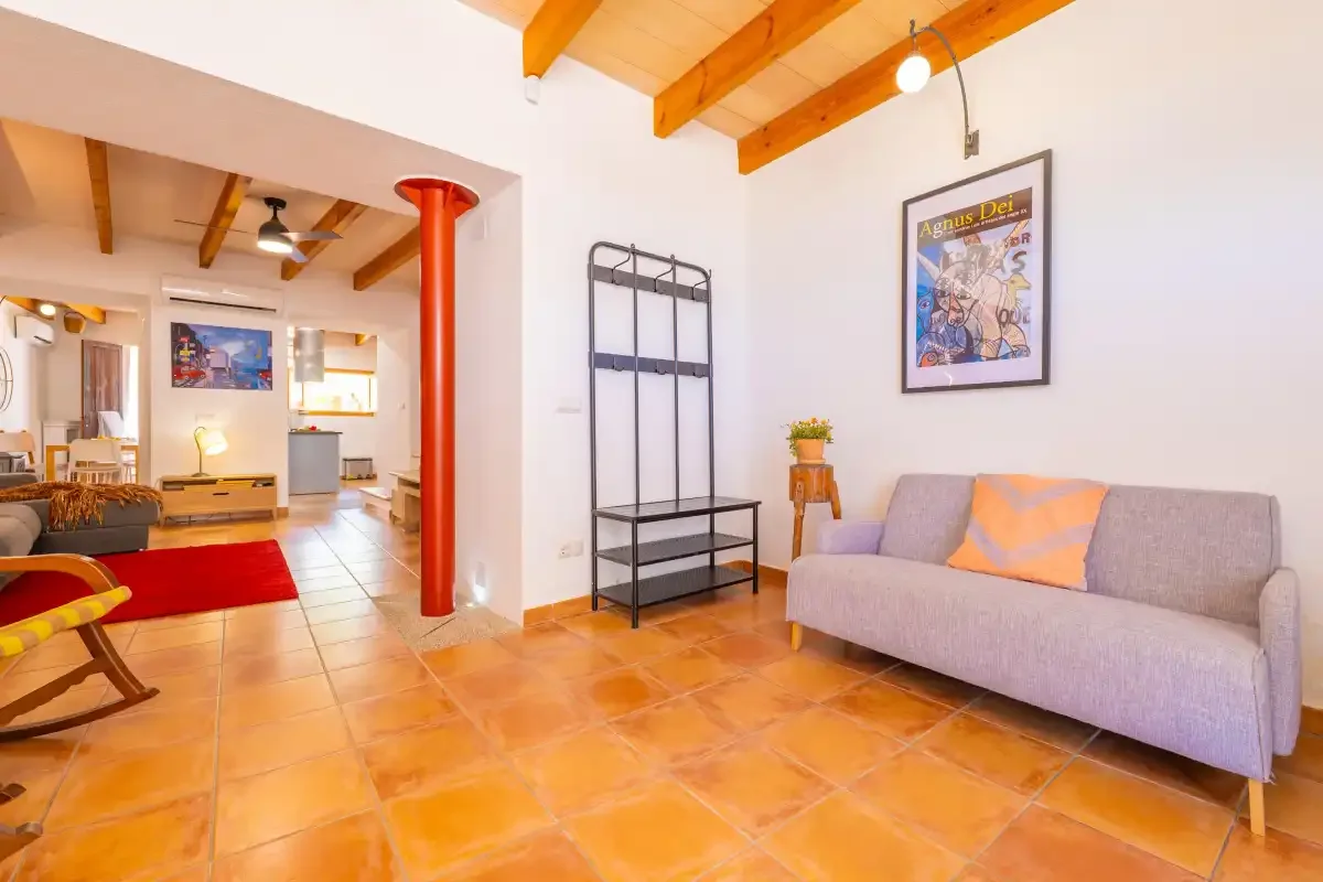 Una sala de estar con un sofá y estanterías abiertas.
