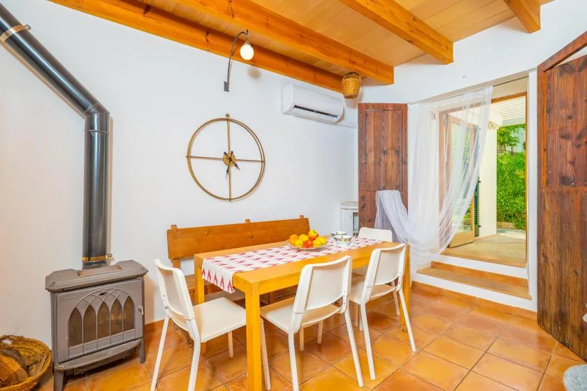 Comedor con una mesa de madera bajo vigas de techo a la vista.