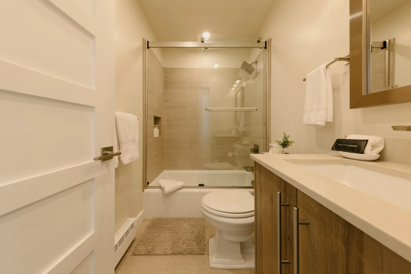 Un baño con una ducha de vidrio y un tocador con lavabo.