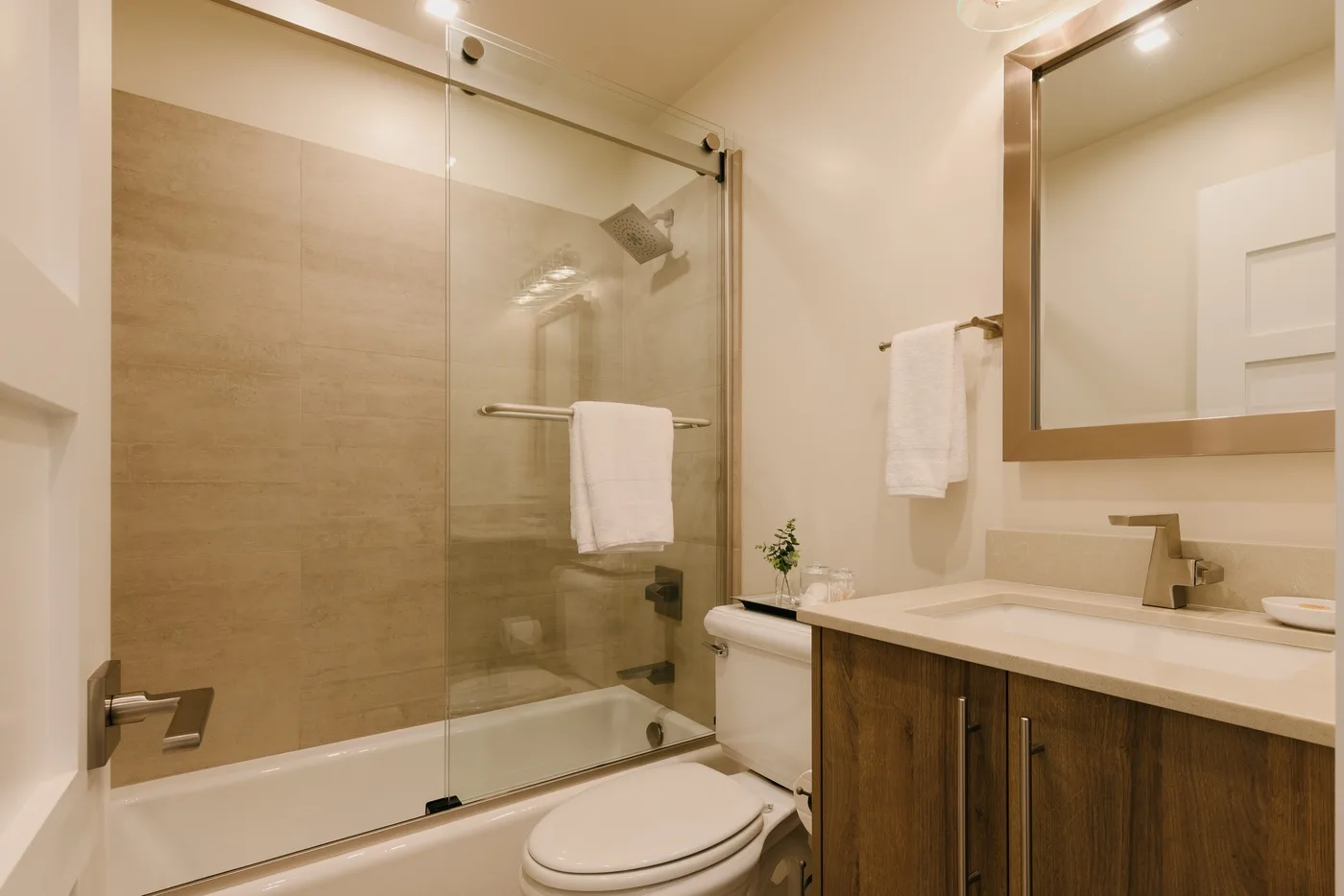 Un baño con ducha de vidrio, bañera y lavabo.