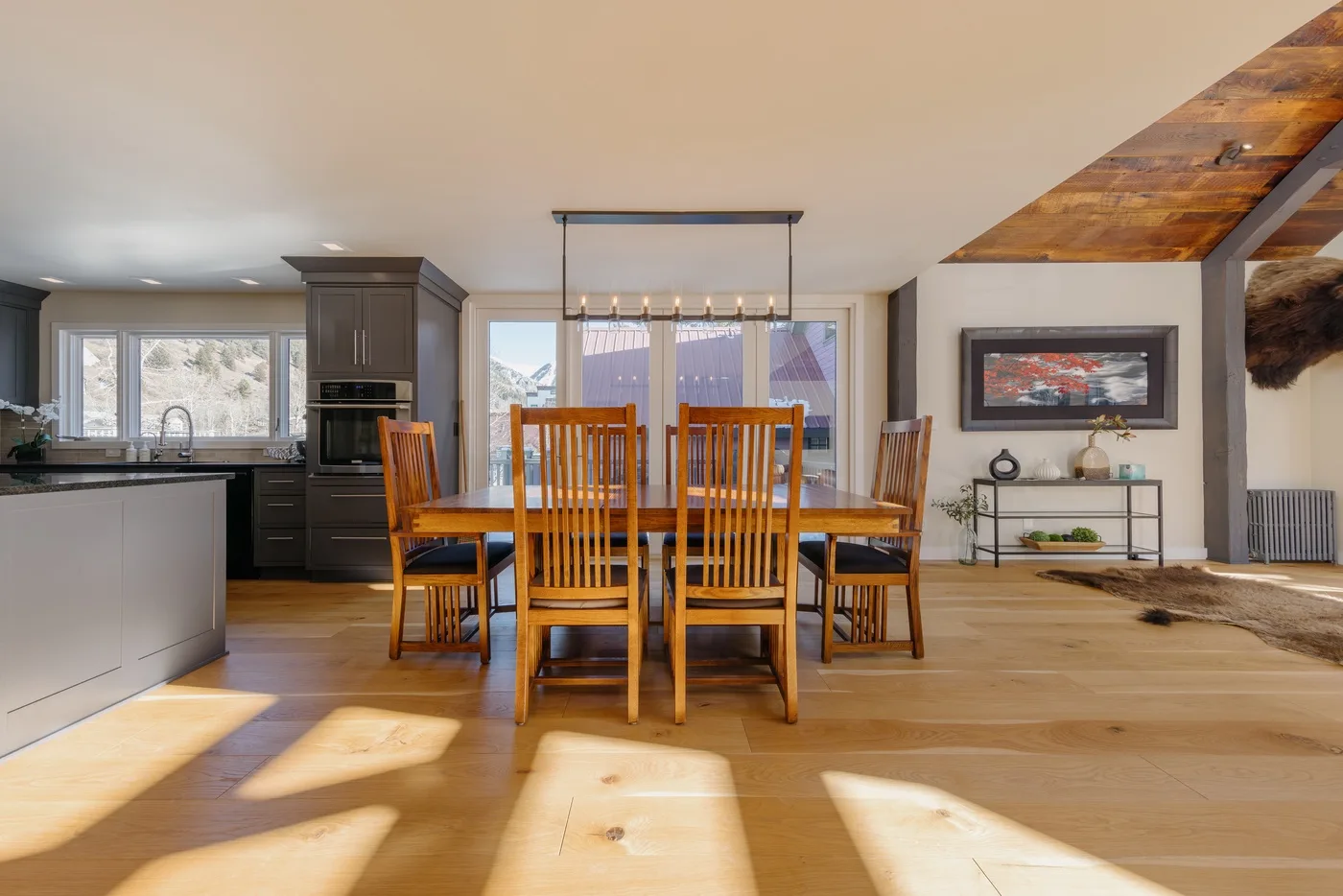 Un comedor abierto con una mesa y sillas de madera junto a la cocina.