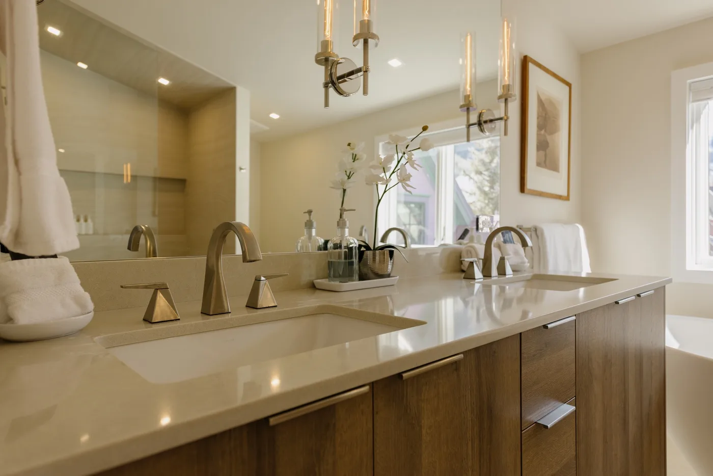 Un tocador de baño luminoso con lavabos, espejos y ventanas.
