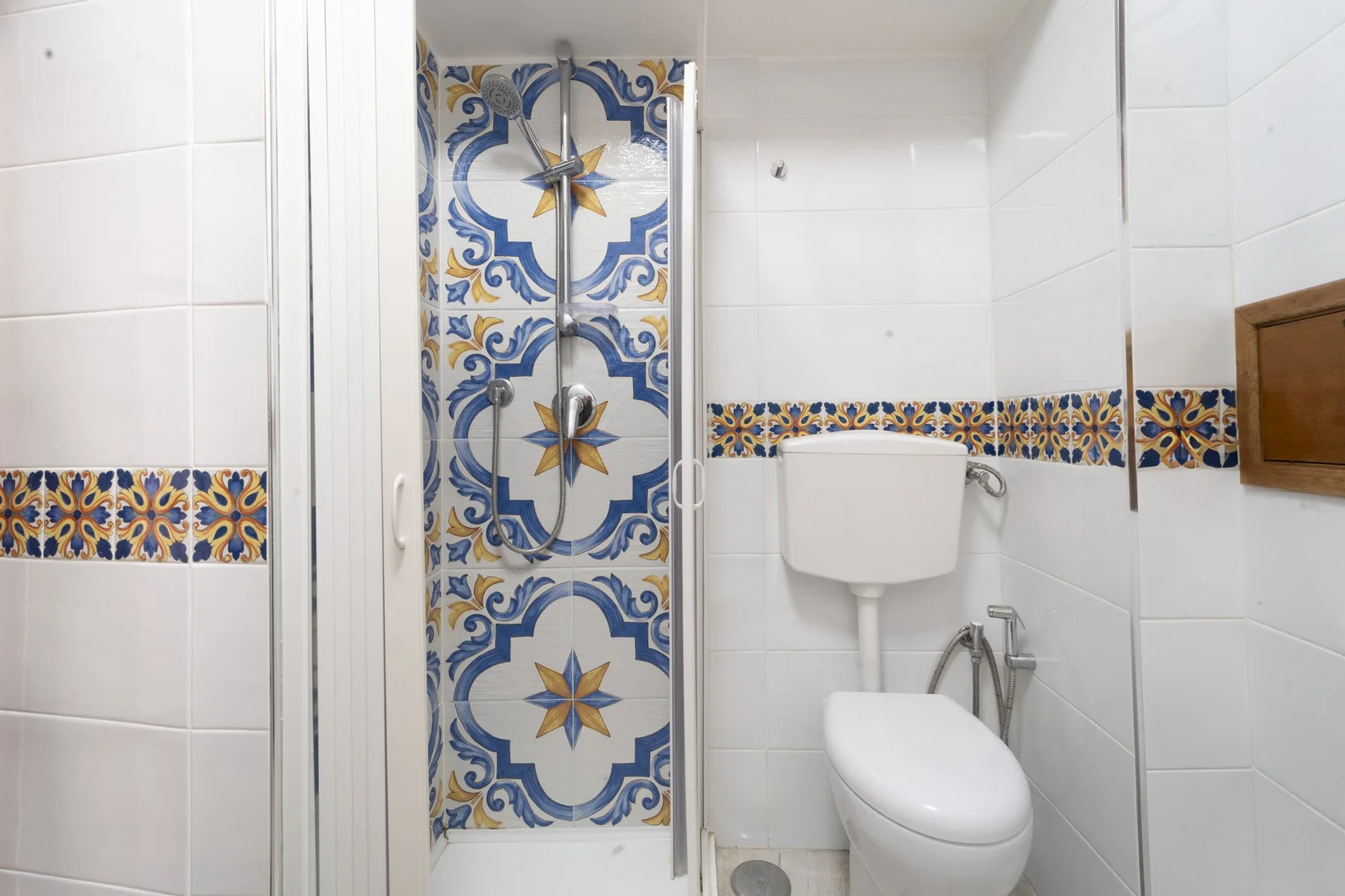 A tiled bathroom with a shower and toilet.