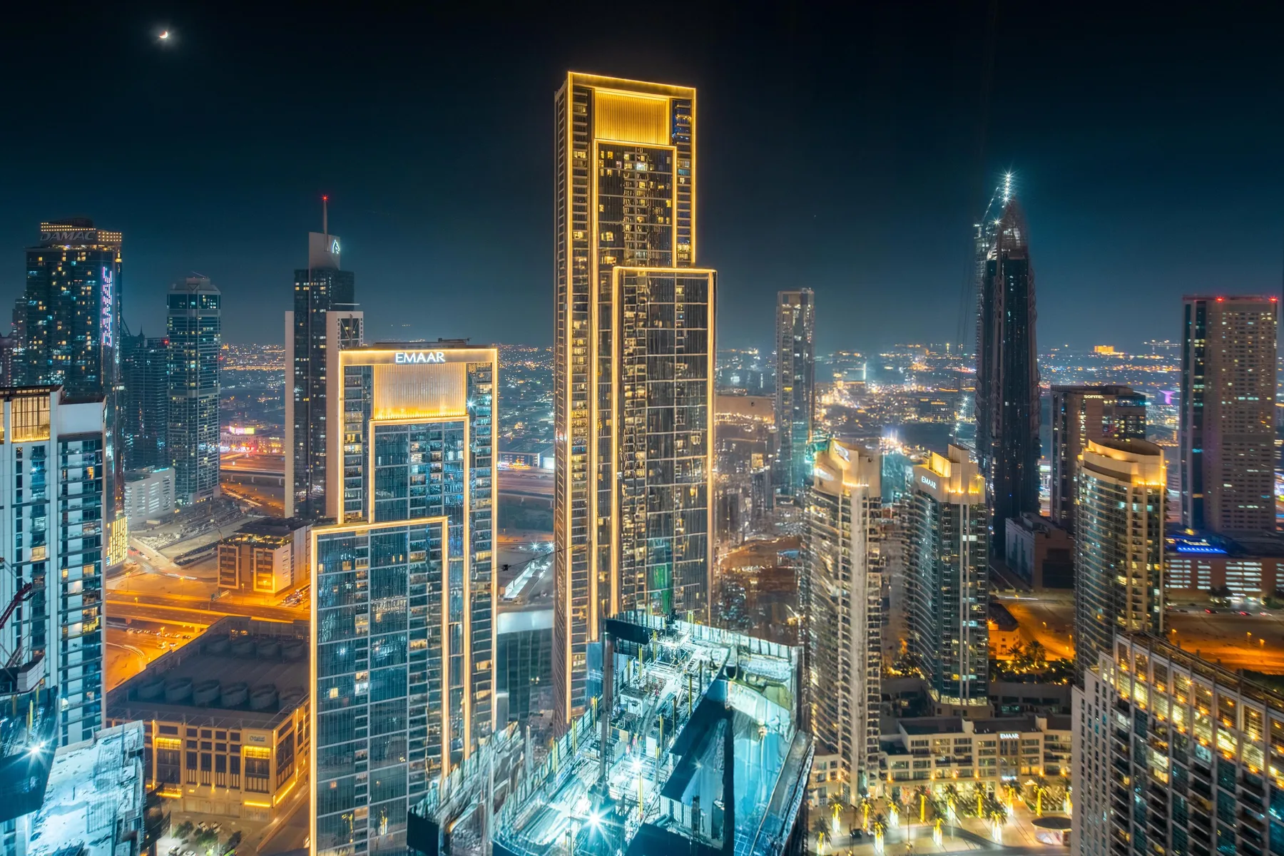 Un horizonte urbano nocturno con edificios altos iluminados.