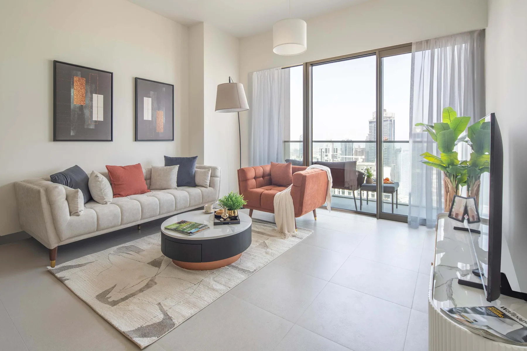 Una sala luminosa con asientos alrededor de una mesa de centro junto a grandes ventanas.