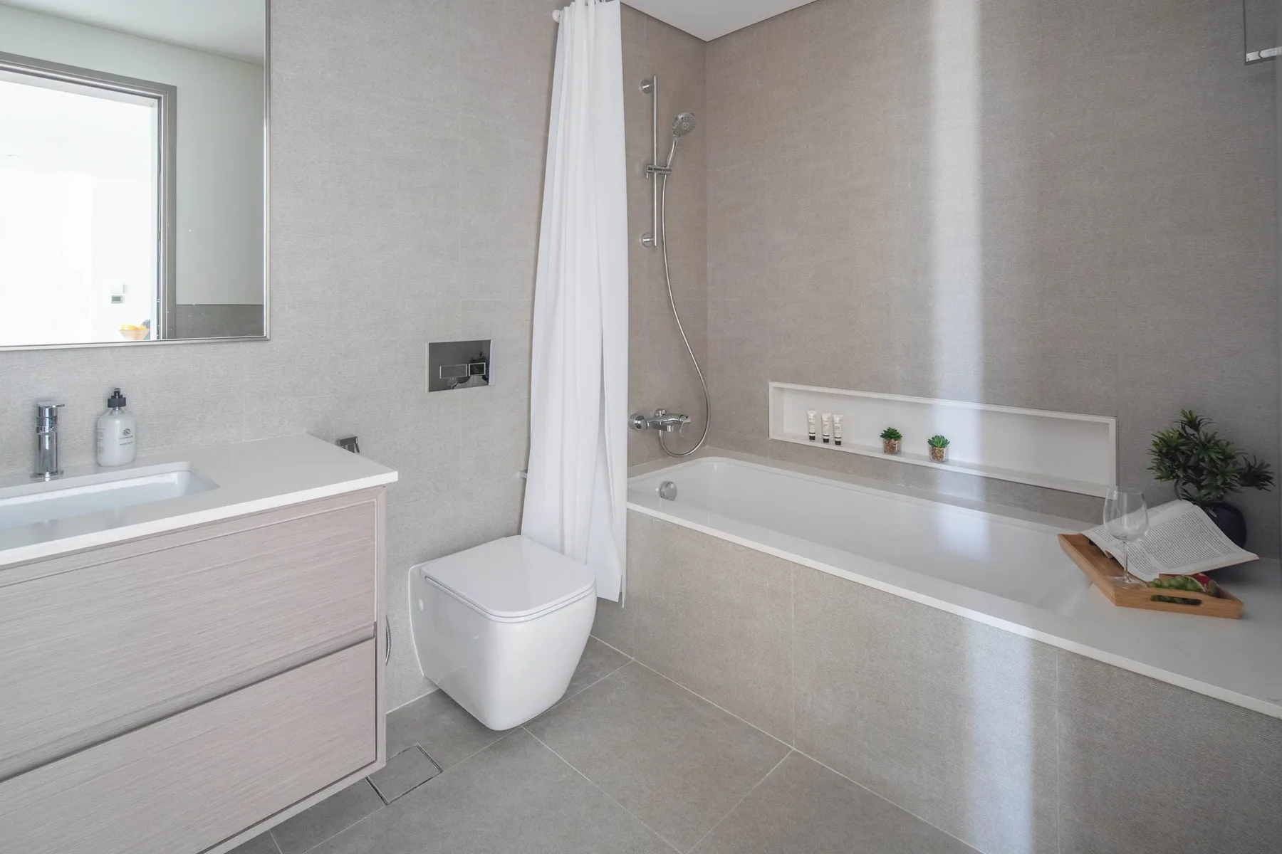 Un baño moderno con bañera, ducha, inodoro y lavabo.