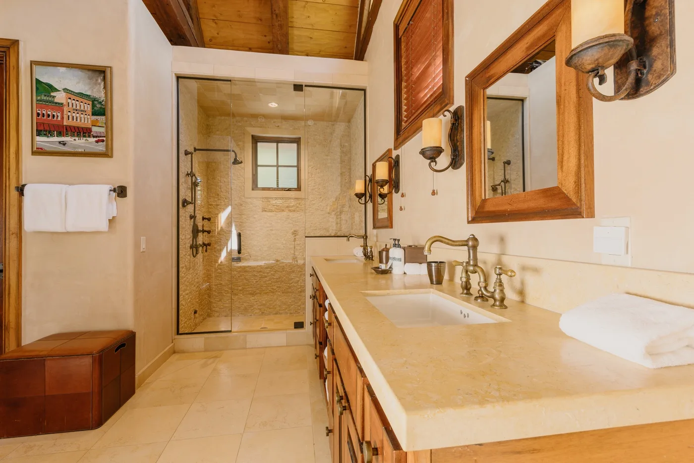 A bathroom with a long vanity and a glass-enclosed shower.